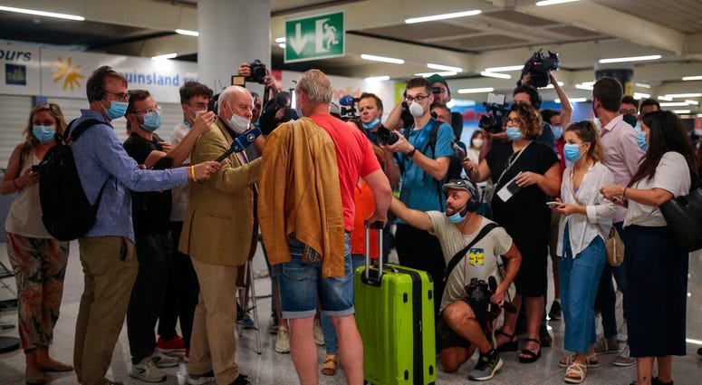 A TUI X3 2312 Duesseldorf-Mallorca flight passenger talks to the press at Son Sant Joan airport in Palma de Mallorca, Spain, Monday, June 15, 2020.