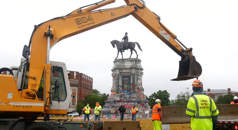 Workers for The Virginia Department of General Services install concrete barriers around the statue of Confederate General Robert E. Lee on Monument Avenue Wednesday June 17, 2020, in Richmond, Va.