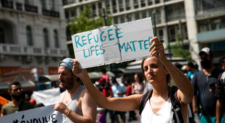 Protesters take part in a rally in favor of migrants who live in Greece, in Athens, on Saturday, June 20, 2020.