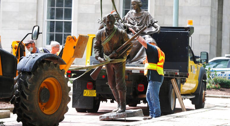 Crews add The Henry Wyatt Monument to a truck after removing them from the North Carolina State Capitol in Raleigh, N.C., Saturday, June 20, 2020.