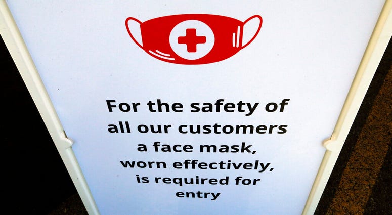 In this Tuesday, June 23, 2020, photo, a "Face Covering" sign is shown at Snider Bros. Meats, in Holladay, Utah.
