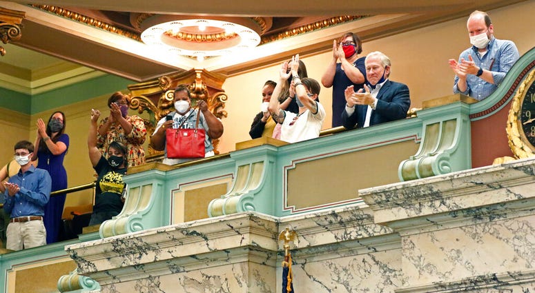 The gallery of the Mississippi Senate rise and applaud after the body passed a resolution that would allow lawmakers to change the state flag Saturday, June 27, 2020, at the Capitol in Jackson, Miss.