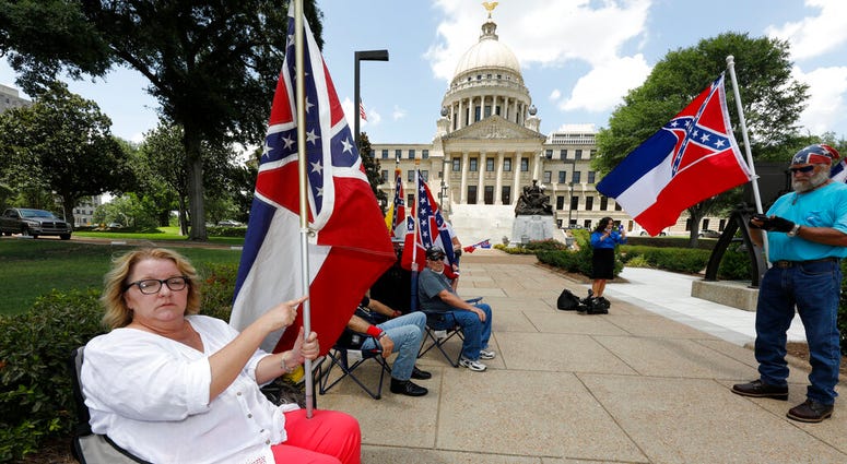 essa Collett of Petal, left, wants her vote to count as she supports the current flag as do other supporters standing outside the state Capitol in Jackson, Miss., Sunday, June 28, 2020.