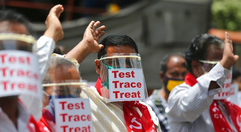 Activists of Communist Party of India Marxist display placards on face shields and shout slogans during a protest asking the state government to increase testing and free treatment for all COVID-19 patients in Hyderabad, India, Monday, June 29, 2020.