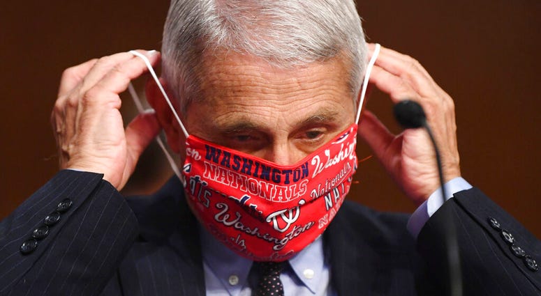 Dr. Anthony Fauci, director of the National Institute for Allergy and Infectious Diseases, lowers his face mask as he prepares to testify before a Senate Health, Education, Labor and Pensions Committee hearing on Capitol Hill in Washington, Tuesday, June