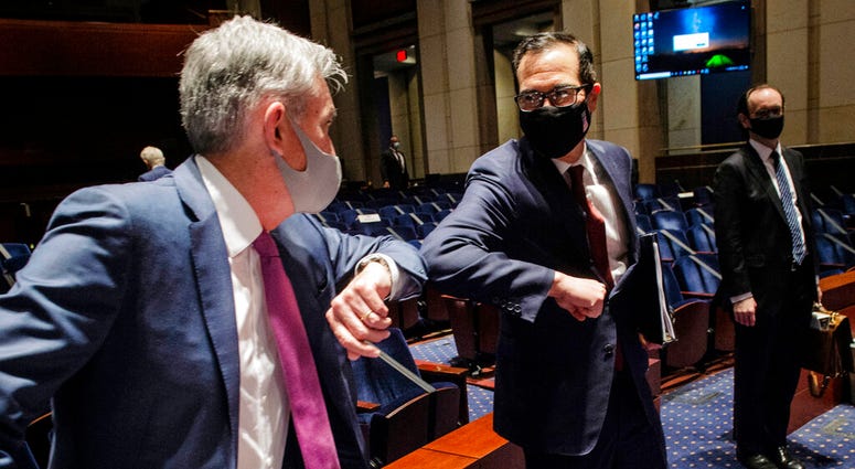Federal Reserve Board Chairman Jerome Powell, left, and Treasury Secretary Stephen Mnuchin, bump elbows at the conclusion of a House Committee on Financial Services hearing on oversight of the Treasury Department and Federal Reserve pandemic response, Tue