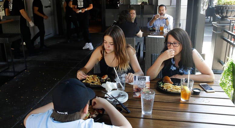 Patrons eat lunch at Slater's 50/50 Wednesday, July 1, 2020, in Santa Clarita, Calif.