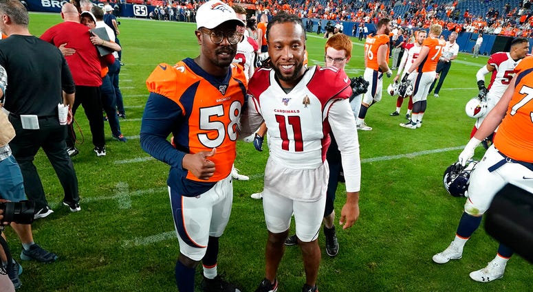 LE - In this Aug. 29, 2019, file photo, Denver Broncos outside linebacker Von Miller (58) greets Arizona Cardinals wide receiver Larry Fitzgerald (11) after an NFL preseason football game in Denver.