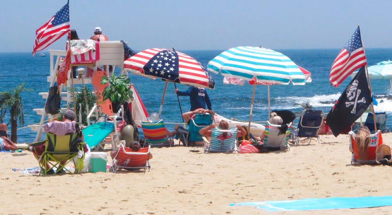 Flags line the beach in Belmar, N.J., on June 28, 2020. With large crowds expected at the Jersey Shore for the July Fourth weekend, some are worried that a failure to heed mask-wearing and social distancing protocols could accelerate the spread of the cor