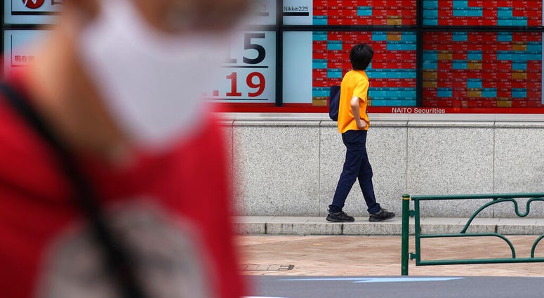 A man looks at an electronic stock board showing Japan's Nikkei 225 index at a securities firm in Tokyo Friday, July 3, 2020. Markets advanced in Asia on Friday following a Wall Street rally driven by strong jobs data.
