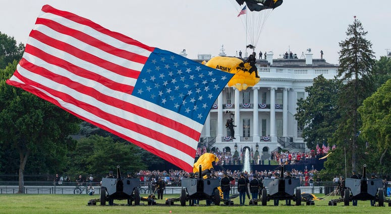 President Donald Trump and first lady Melania Trump watch as the U.S. Army Golden Knights Parachute Team descend during a "Salute to America" event on the South Lawn of the White House, Saturday, July 4, 2020, in Washington.