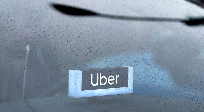 FILE - In this May 15, 2020 file photo, an Uber sign is displayed inside a car in Chicago. (AP Photo/Nam Y. Huh, File) FILE - In this May 15, 2020 file photo, an Uber sign is displayed inside a car in Chicago. (AP Photo/Nam Y. Huh, File)