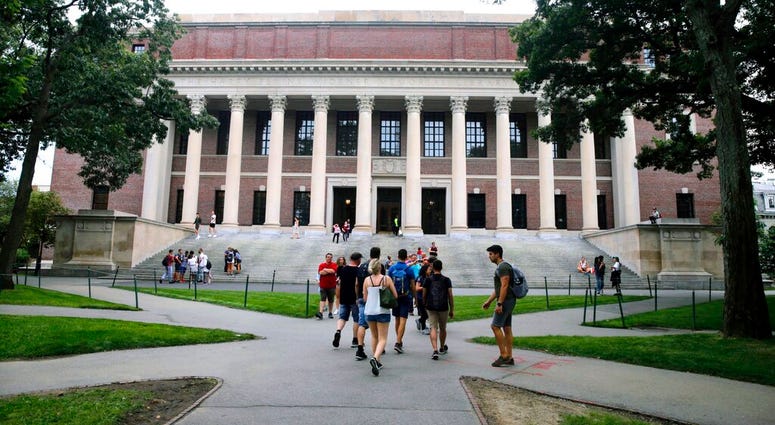 FILE - In this Aug. 13, 2019 file photo, students walk near the Widener Library in Harvard Yard at Harvard University in Cambridge, Mass.