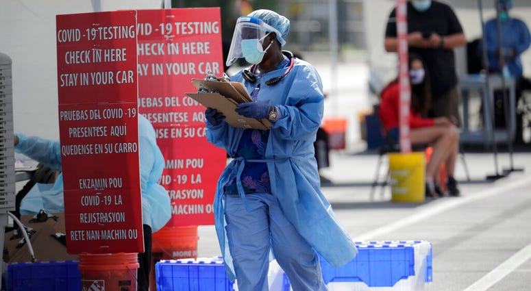 A health care worker works at a COVID-19 testing site sponsored by Community Heath of South Florida at the Martin Luther King, Jr. Clinica Campesina Health Center, during the coronavirus pandemic, Monday, July 6, 2020, in Homestead, Fla.