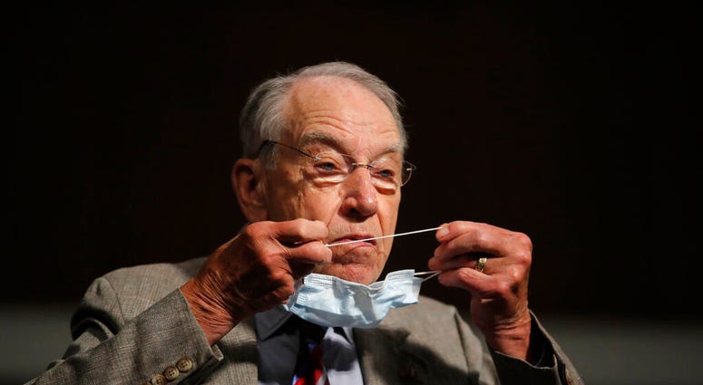 FILE - In this June 11, 2020, file photo, Sen. Chuck Grassley, R-Iowa, puts on a face mask during a Senate Judiciary Committee on Capitol Hill in Washington.