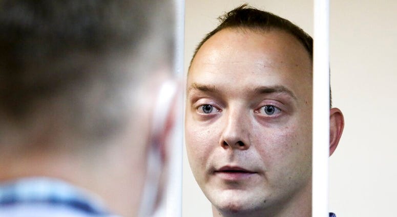 Ivan Safronov, an adviser to the director of Russia's state space corporation, stands behind bars in a courtroom in Moscow, Russia, Tuesday, July 7, 2020.