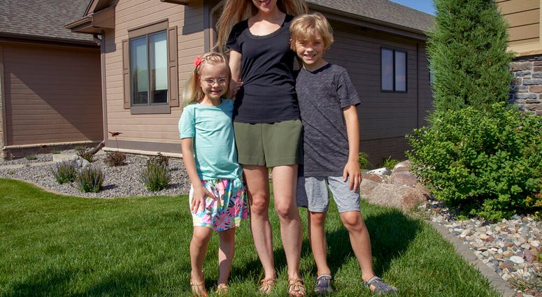 Tara Carlson poses for a photo with her children Kyler, 9, and Alayna, 6, outside their home in Omaha, Neb., Tuesday, July 7, 2020. Carlson pulled her kids out of summer camp at the last minute, losing $300 in deposits.