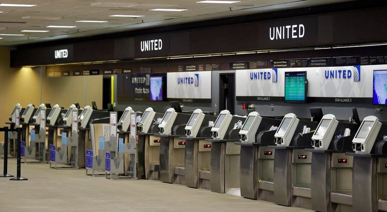 FILE - In this April 24, 2020 file photo, empty United Airlines ticket machines are shown at the Tampa International Airport in Tampa, Fla.