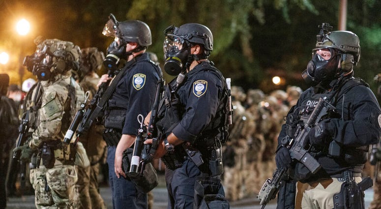 In this photo provided by Doug Brown, agents from different components of the Department of Homeland Security are deployed to protect a federal courthouse in Portland, Ore., on Sunday, July 5, 2020.