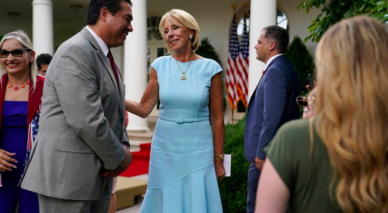 Education Secretary Betsy DeVos speaks with Jesus Marquez, President of Marquez Group Strategies, after President Donald Trump signed an executive order on the "White House Hispanic Prosperity Initiative," in the Rose Garden of the White House, Thursday,