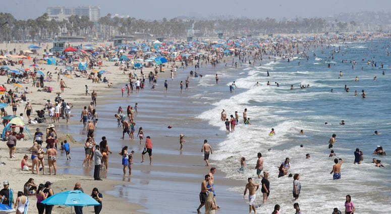 Visitors crowd the beach Sunday, July 12, 2020, in Santa Monica, Calif., amid the coronavirus pandemic.