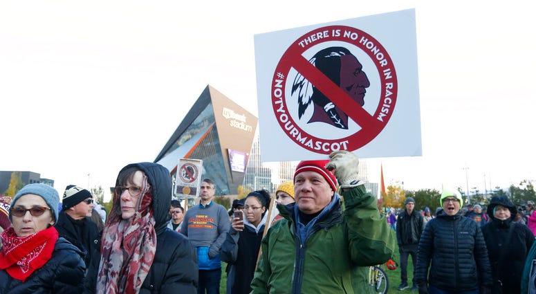 FILE - In this Oct. 24, 2019, file photo, Native American leaders protest against the Redskins team name outside U.S. Bank Stadium before an NFL football game between the Minnesota Vikings and the Washington Redskins in Minneapolis.