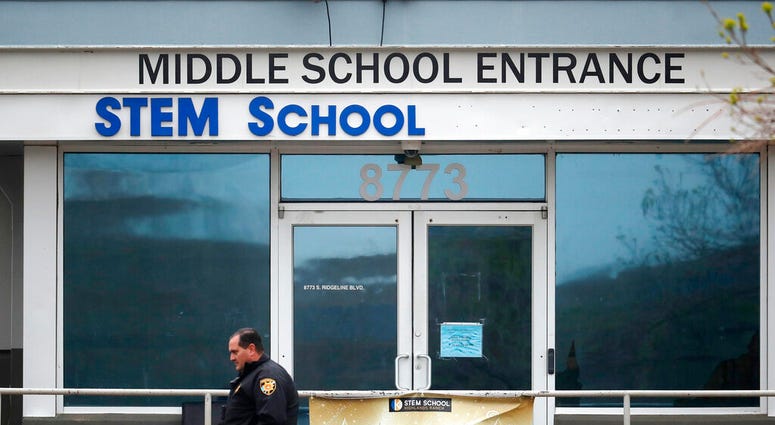 FILE - In this May 8, 2019, file photo, a Douglas County, Colo., Sheriff's deputy walks past the doors of the STEM Highlands Ranch school in Highlands Ranch, Colo.