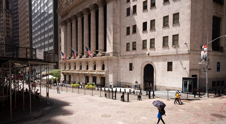 FILE - People pass the New York Stock Exchange, Thursday, July 30, 2020.