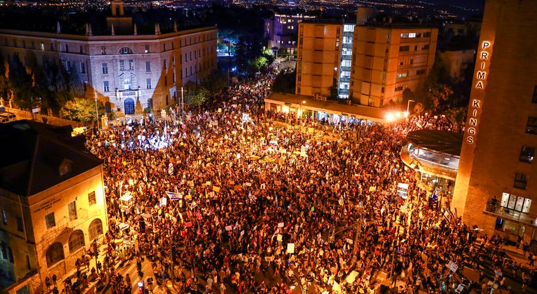 Thousands of protesters chant slogans and hold signs during a protest against Israel's Prime Minister Benjamin Netanyahu outside his residence in Jerusalem, Saturday, Aug 1, 2020.