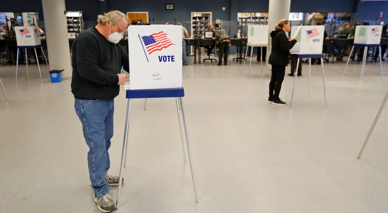 This Tuesday, April 28, 2020 file photo shows Jerome Fedor, left, voting using social distancing at the Cuyahoga County Board of Elections, in Cleveland, Ohio.