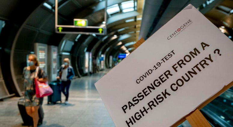 A sign helps passengers to find the Cover-19 test center at the airport in Frankfurt, Germany, Saturday, Aug. 8, 2020. From Saturday on Covid-19 tests are mandatory for passengers coming from a high-risk-country.