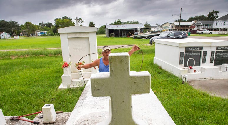 Jerry Parria uses steel cable and metal anchors to tie down four tombs belonging to his grandparents and uncles in a small cemetery near Lafitte, La. (Chris Granger/The Times-Picayune/The New Orleans Advocate via AP) Jerry Parria uses steel cable and metal anchors to tie down four tombs belonging to his grandparents and uncles in a small cemetery near Lafitte, La. (Chris Granger/The Times-Picayune/The New Orleans Advocate via AP)