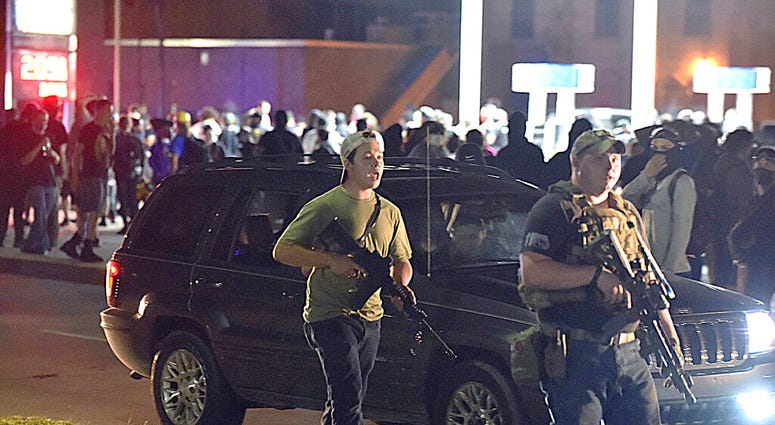 Kyle Rittenhouse, left, with backwards cap, walks along Sheridan Road in Kenosha, Wis., Tuesday, Aug. 25, 2020, with another armed civilian.(Adam Rogan/The Journal Times via AP) Kyle Rittenhouse, left, with backwards cap, walks along Sheridan Road in Kenosha, Wis., Tuesday, Aug. 25, 2020, with another armed civilian.(Adam Rogan/The Journal Times via AP)