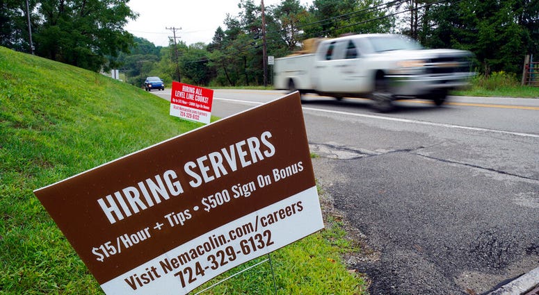 FILE - In this Wednesday, Sept. 2, 2020, file photo help wanted signs for servers and cooks at Nemacolin Woodlands Resort and Spa are displayed along route 40 at the entrance to the resort in Farmington, Pa.