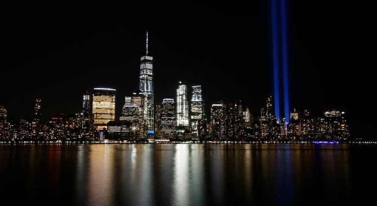 FILE - In this Sept. 11, 2017, file photo, the Tribute in Light illuminates in the sky above the Lower Manhattan area of New York, as seen from across the Hudson River in Jersey City, N.J.
