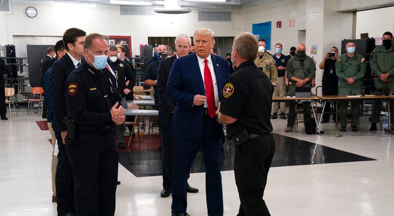 In this Sept. 1, 2020 file photo, President Donald Trump tours an emergency operations center and meets with law enforcement officers at Mary D. Bradford High School in Kenosha, Wis. (AP Photo/Evan Vucci File) In this Sept. 1, 2020 file photo, President Donald Trump tours an emergency operations center and meets with law enforcement officers at Mary D. Bradford High School in Kenosha, Wis. (AP Photo/Evan Vucci File)