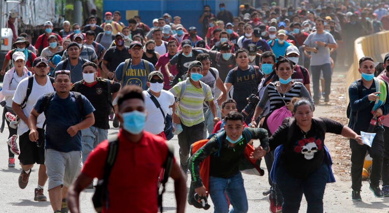 Migrants attempt to cross the border from Corinto, Honduras, into Corinto, Guatemala, Thursday, Oct. 1, 2020. (AP Photo) Migrants attempt to cross the border from Corinto, Honduras, into Corinto, Guatemala, Thursday, Oct. 1, 2020. (AP Photo)
