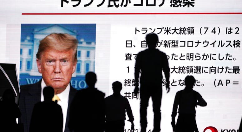 People walk past a screen showing the news report that President Donald Trump has tested positive for the coronavirus, Friday, Oct. 2, 2020, in Tokyo. (AP Photo/Eugene Hoshiko) People walk past a screen showing the news report that President Donald Trump has tested positive for the coronavirus, Friday, Oct. 2, 2020, in Tokyo. (AP Photo/Eugene Hoshiko)