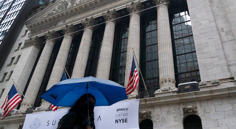 A woman with an umbrella passes the New York Stock Exchange, Monday, Oct. 26, 2020. (AP Photo/Mark Lennihan) A woman with an umbrella passes the New York Stock Exchange, Monday, Oct. 26, 2020. (AP Photo/Mark Lennihan)