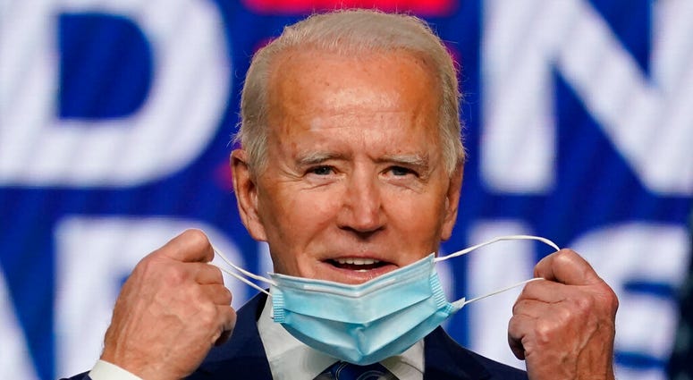 Democratic presidential candidate former Vice President Joe Biden takes off his face mask as he arrives to speak, Wednesday, Nov. 4, 2020, in Wilmington, Del. (AP Photo/Carolyn Kaster) Democratic presidential candidate former Vice President Joe Biden takes off his face mask as he arrives to speak, Wednesday, Nov. 4, 2020, in Wilmington, Del. (AP Photo/Carolyn Kaster)