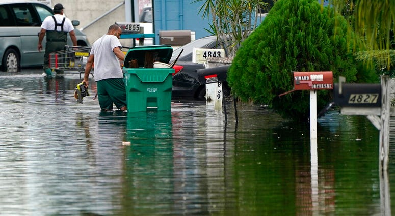 Residents clear debris from a flooded street in the Driftwood Acres Mobile Home Park, in the aftermath of Tropical Storm Eta, Tuesday, Nov. 10, 2020, in Davie, Fla. (AP Photo/Lynne Sladky) Residents clear debris from a flooded street in the Driftwood Acres Mobile Home Park, in the aftermath of Tropical Storm Eta, Tuesday, Nov. 10, 2020, in Davie, Fla. (AP Photo/Lynne Sladky)