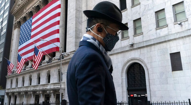 A man wearing a mask passes the New York Stock Exchange, Monday, Nov. 16, 2020, in New York. Stock markets are rallying on news that a second coronavirus vaccine shows promise. (AP Photo/Mark Lennihan) A man wearing a mask passes the New York Stock Exchange, Monday, Nov. 16, 2020, in New York. Stock markets are rallying on news that a second coronavirus vaccine shows promise. (AP Photo/Mark Lennihan)