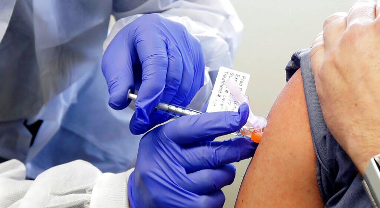 FILE - In this March 16, 2020, file photo, Neal Browning receives a shot in the first-stage safety study of a potential vaccine for COVID-19 at the Kaiser Permanente Washington Health Research Institute in Seattle. (AP Photo/Ted S. Warren, File) FILE - In this March 16, 2020, file photo, Neal Browning receives a shot in the first-stage safety study of a potential vaccine for COVID-19 at the Kaiser Permanente Washington Health Research Institute in Seattle. (AP Photo/Ted S. Warren, File)