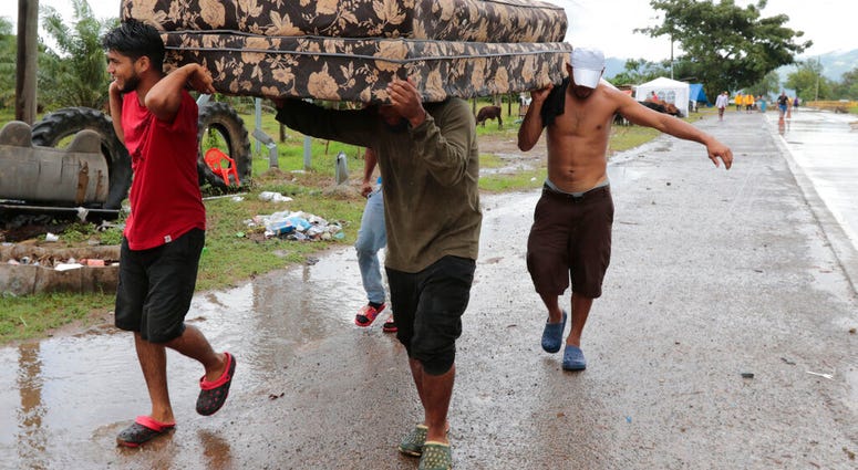 Neighbors help each other as they evacuate the area before Hurricane Iota makes landfall in San Manuel Cortes, Honduras, Monday, November 16, 2020. (AP Photo/Delmer Martinez) Neighbors help each other as they evacuate the area before Hurricane Iota makes landfall in San Manuel Cortes, Honduras, Monday, November 16, 2020. (AP Photo/Delmer Martinez)