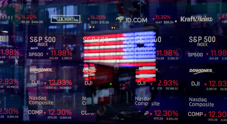 In this March 16, 2020 file photo, a United States flag is reflected in the window of the Nasdaq studio, which displays indices and stocks down, in Times Square, New York. (AP Photo/Seth Wenig, File) In this March 16, 2020 file photo, a United States flag is reflected in the window of the Nasdaq studio, which displays indices and stocks down, in Times Square, New York. (AP Photo/Seth Wenig, File)