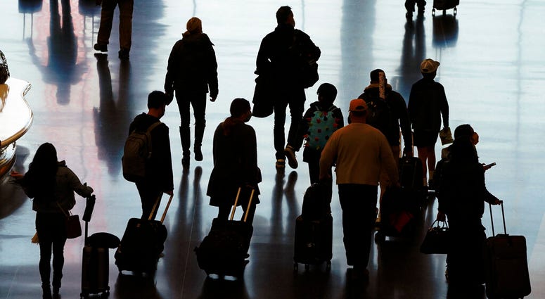 In this Wednesday, Nov. 25, 2020 file photo, travelers walk through the Salt Lake City International Airport in Salt Lake City, a day before Thanksgiving. (AP Photo/Rick Bowmer) In this Wednesday, Nov. 25, 2020 file photo, travelers walk through the Salt Lake City International Airport in Salt Lake City, a day before Thanksgiving. (AP Photo/Rick Bowmer)