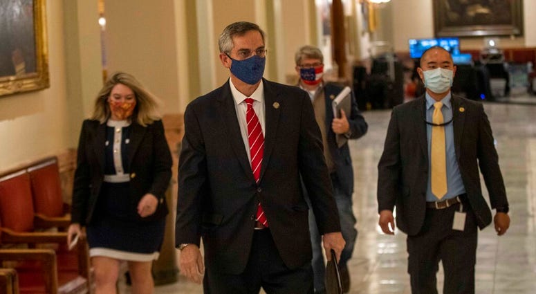 Georgia Secretary of State Brad Raffensperger, center, walks with members of his staff as they make their way to a press conference at the Georgia State Capitol building in Atlanta. (Alyssa Pointer/Atlanta Journal-Constitution via AP) Georgia Secretary of State Brad Raffensperger, center, walks with members of his staff as they make their way to a press conference at the Georgia State Capitol building in Atlanta. (Alyssa Pointer/Atlanta Journal-Constitution via AP)