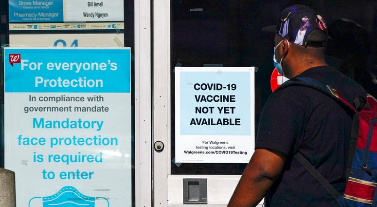 FILE - In this Dec. 2, 2020, file photo, a customer walks past a sign indicating that a COVID-19 vaccine is not yet available at Walgreens in Long Beach, Calif. (AP Photo/Ashley Landis, File) FILE - In this Dec. 2, 2020, file photo, a customer walks past a sign indicating that a COVID-19 vaccine is not yet available at Walgreens in Long Beach, Calif. (AP Photo/Ashley Landis, File)