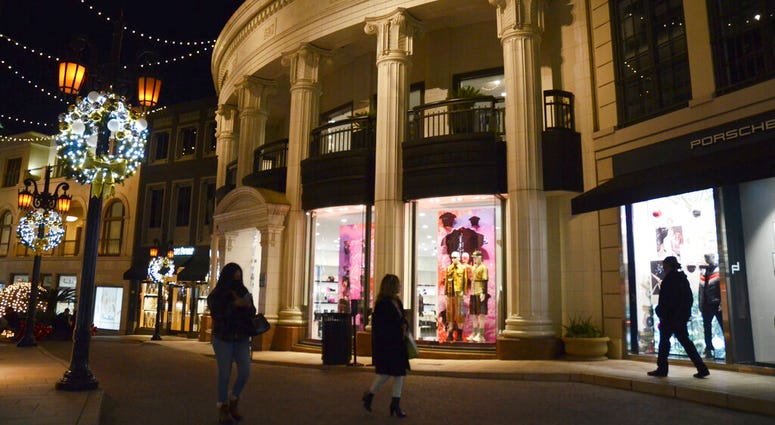 People walk near the Versace boutique on Rodeo Drive, decorated for the holidays amid the coronavirus pandemic, Monday, Nov. 30, 2020, in Beverly Hills, Calif. (AP Photo/Pamela Hassell) People walk near the Versace boutique on Rodeo Drive, decorated for the holidays amid the coronavirus pandemic, Monday, Nov. 30, 2020, in Beverly Hills, Calif. (AP Photo/Pamela Hassell)