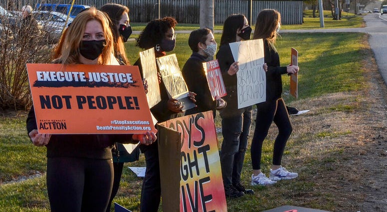 Protesters line Prairieton Road across from the Federal Execution Chamber, Thursday, Dec. 10, 2020 in Terre Haute, Ind.